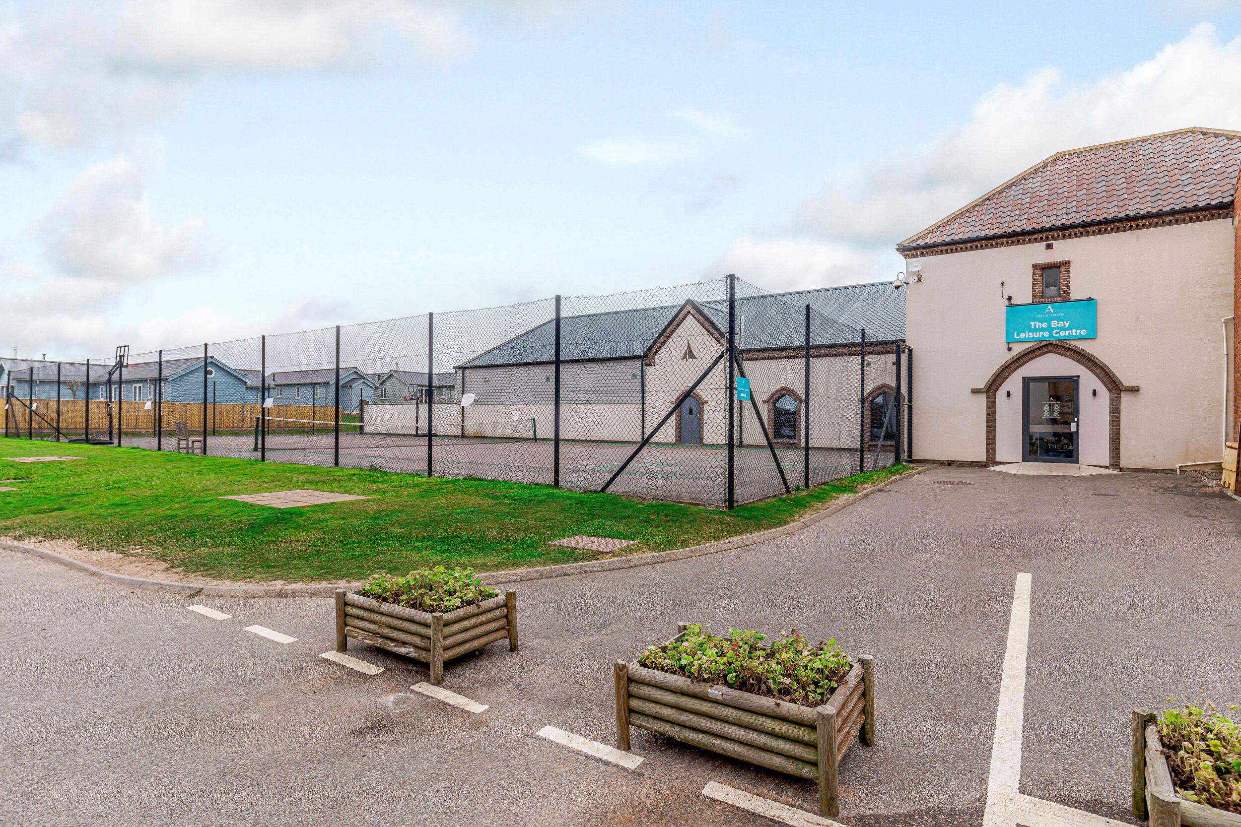A fenced outdoor area with a building labeled "The Bay Leisure Centre" and a paved walkway.