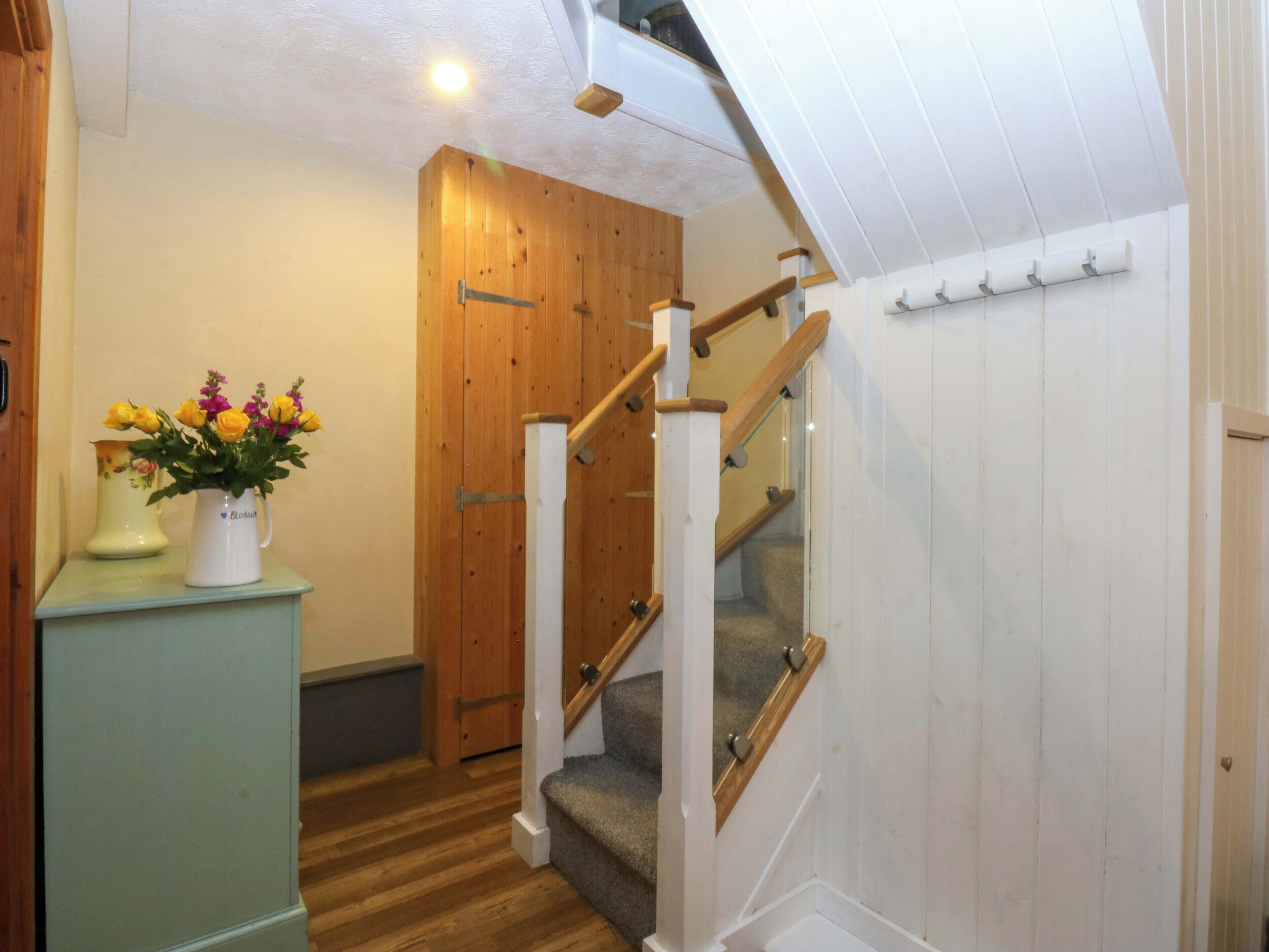 A staircase with wooden railings and a carpeted landing.