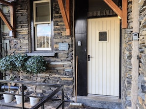 Kelsick Heights features a traditional stone building with a welcoming entrance and outdoor seating area.