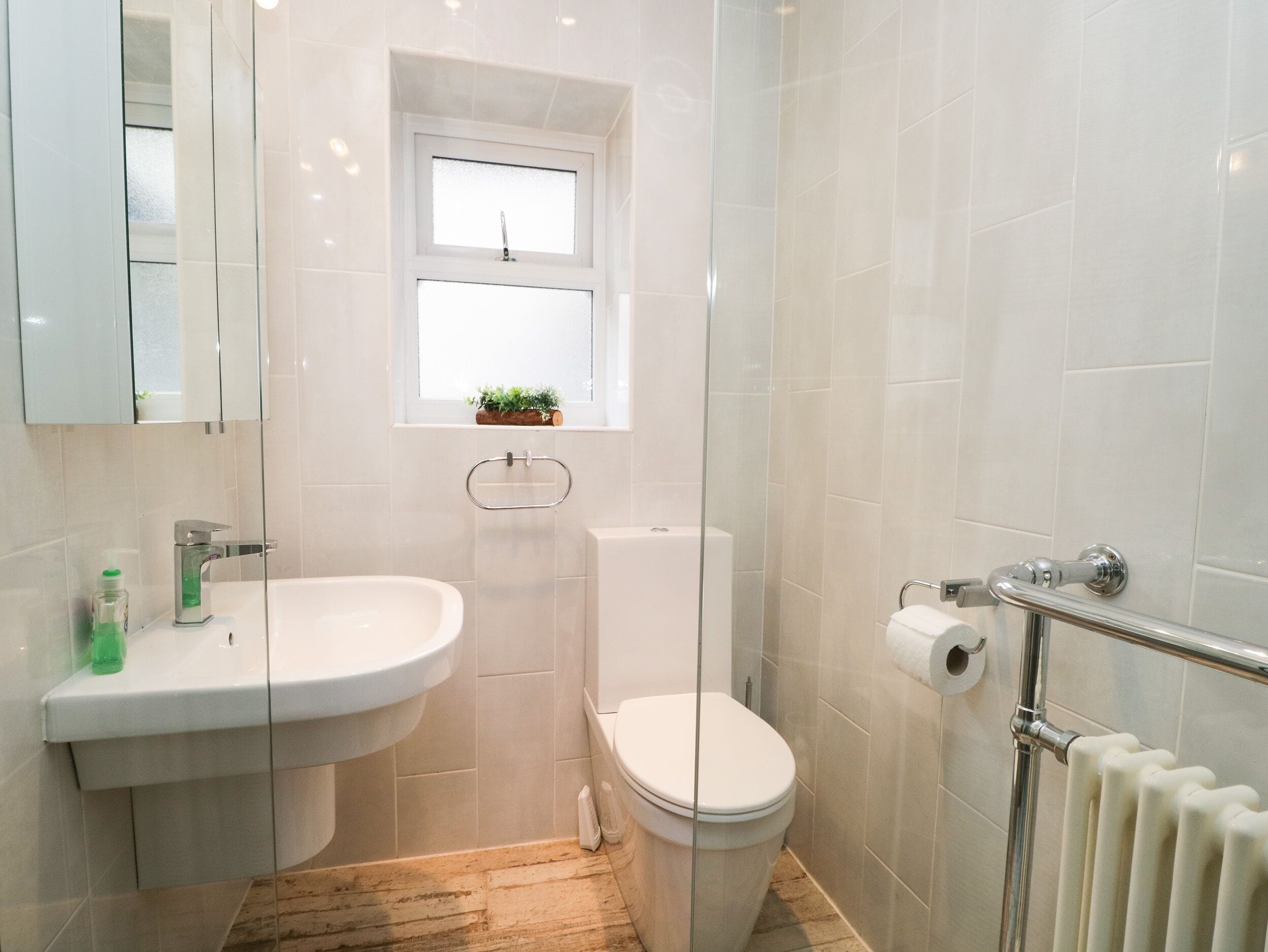 Een badkamer met een wit wastafel, toilet en een douchecabine van glas.