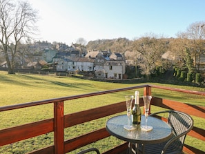 Enjoy a meal or drink on the terrace with a view of the lush green lawn and traditional stone houses.