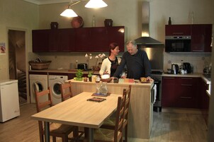 Cocina compacta con comedor, equipada con lavadora, horno y microondas.