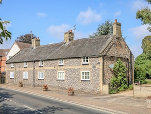 A stone building with multiple windows and a sloped roof.