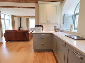 Enjoy cooking in this well-equipped kitchen with a spacious countertop, adjacent to a cozy living area with a fireplace and comfortable seating.