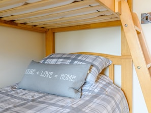Cozy retreat with a bunk bed featuring a plaid-patterned mattress and pillows.