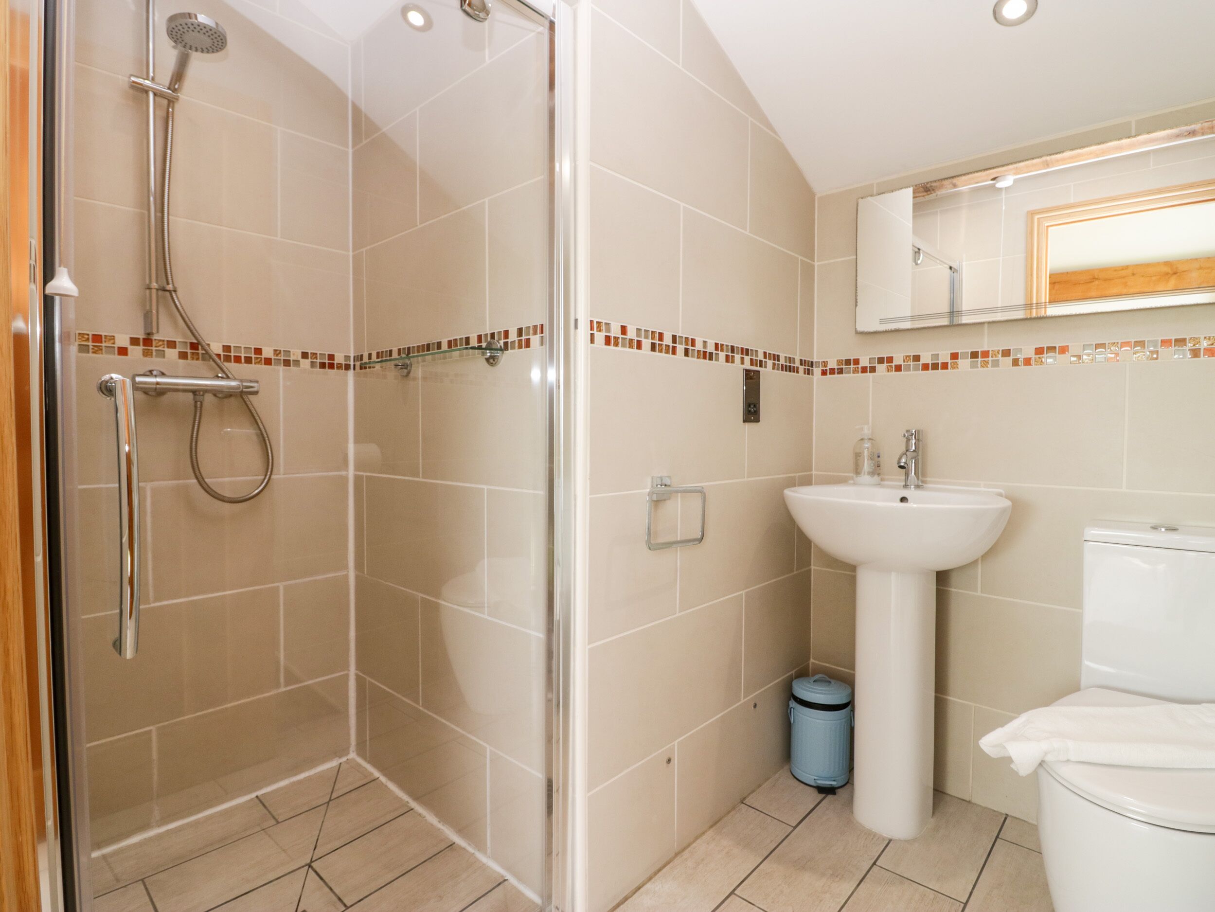 Une salle de bain moderne avec une douche à parois de verre, un lavabo blanc et des toilettes.