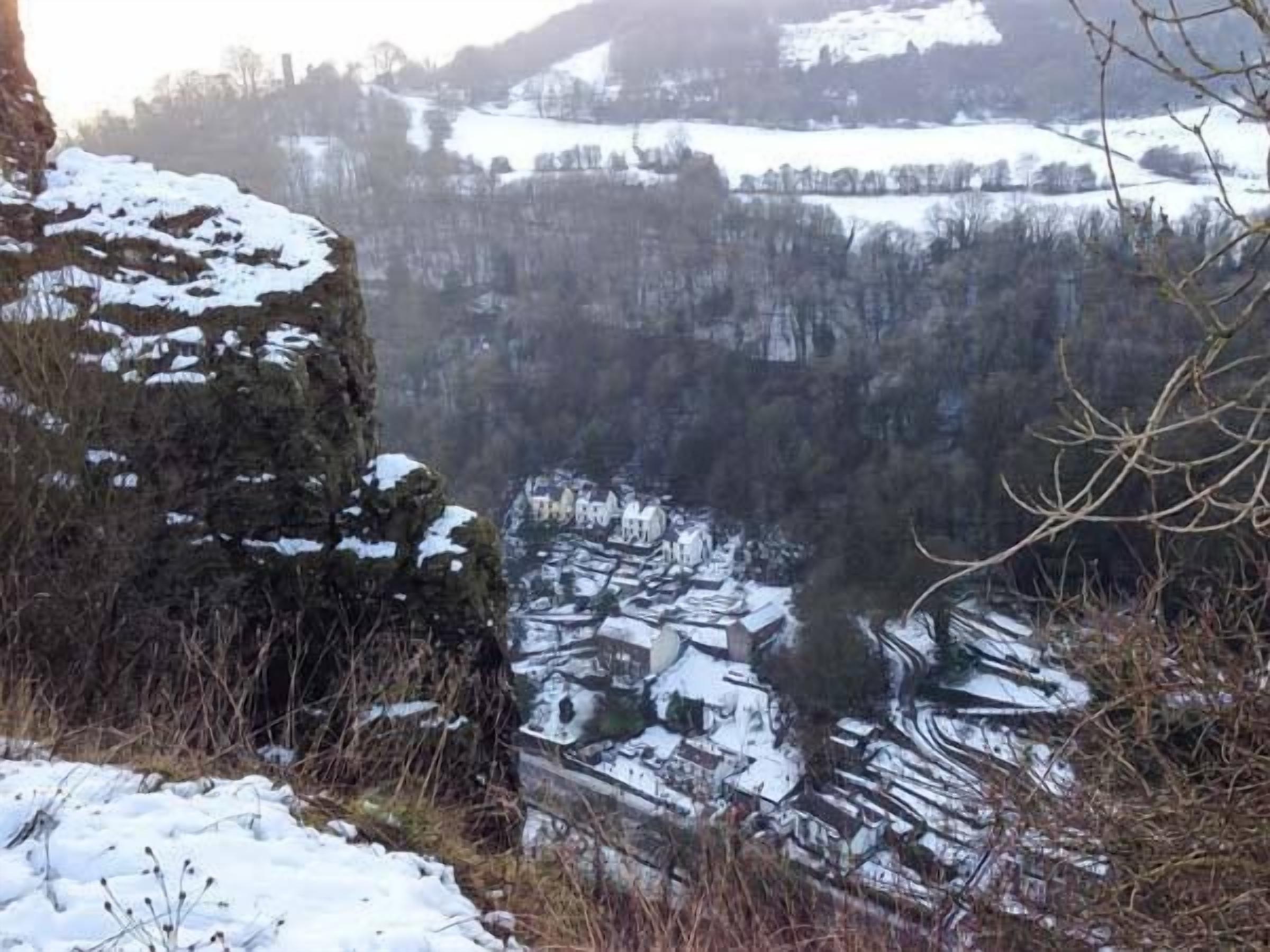 A snow-covered village with buildings and a river.