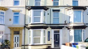 A corner house with bay windows, a black door, and a sign reading "NEPTUNE". - Flat 3 (Bridlington)