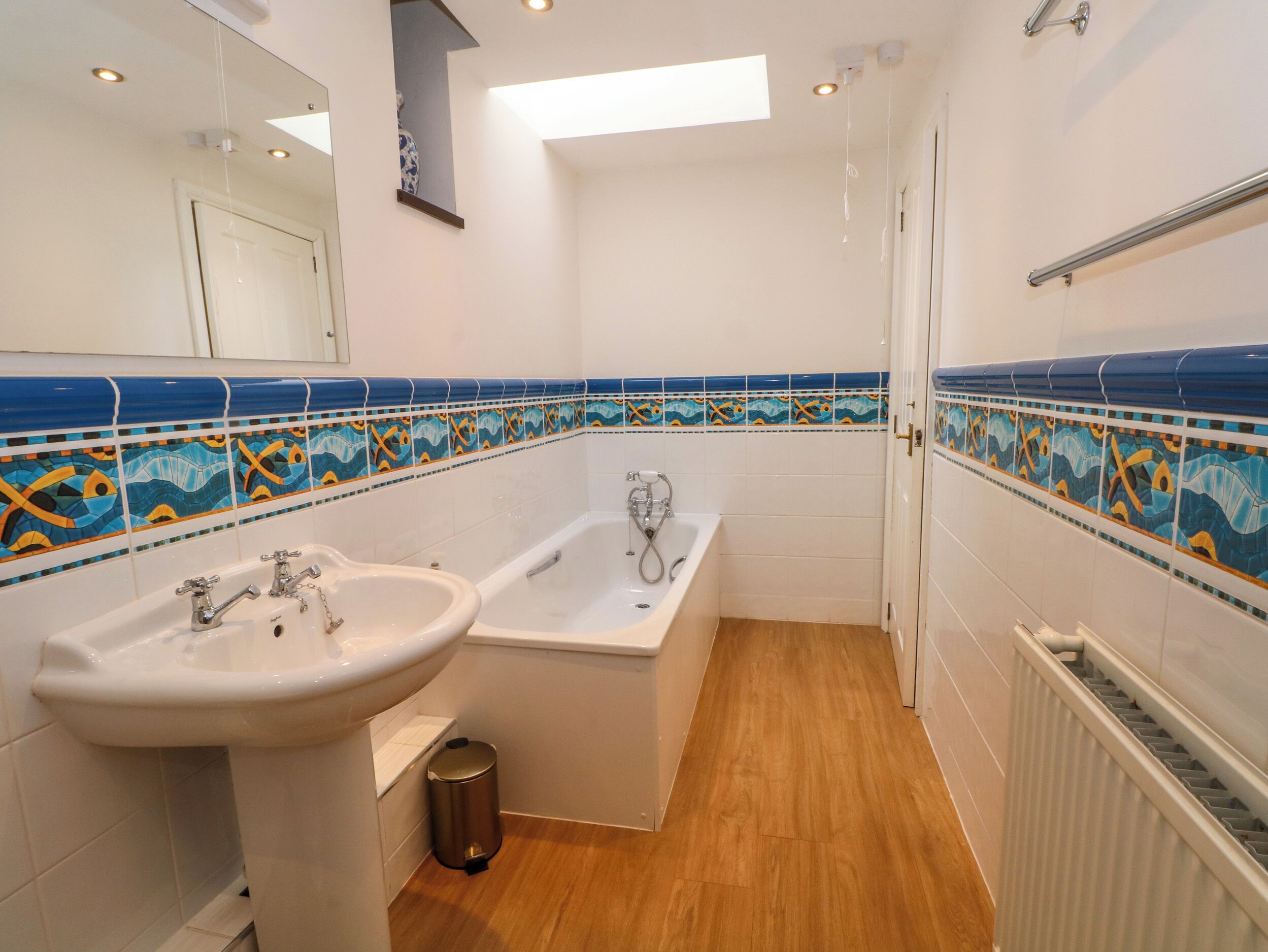 Un baño con bañera, lavamanos y espejo.