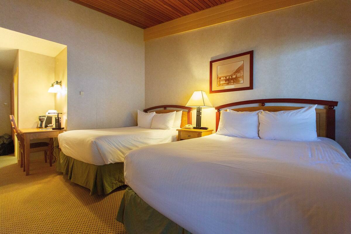 Una habitación de hotel con dos camas, un escritorio y una silla.