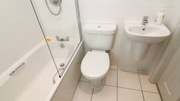Un baño con bañera, inodoro y lavamanos.