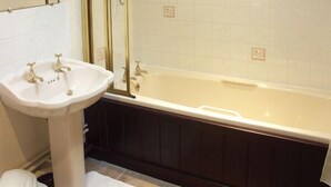 A bathroom with a white sink, a bathtub, and a shower enclosure. - Brook Cottage (Gillingham)