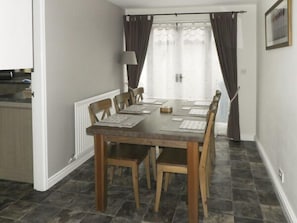 Enjoy meals and games in this cozy dining area with a table for six and a warm atmosphere.