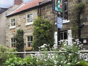 Traditional pub or restaurant with a lush garden and car park.