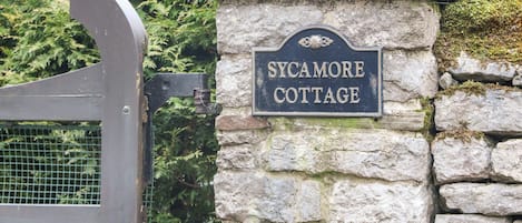Eine Steinsäule mit dem Schild "Sycamore Cottage".