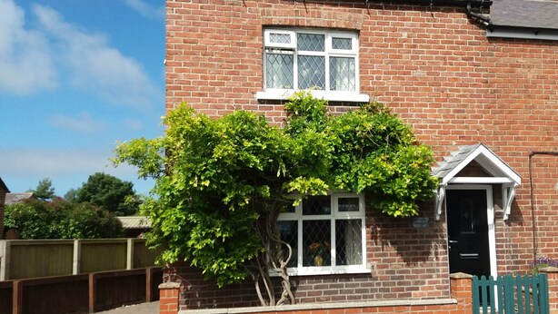 A brick house with a small front garden and a window with a white frame. - Sunnyside Cottage (Filey)