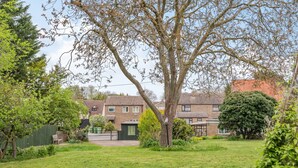 A residential area with houses, a large tree, and a lawn. - Violet Cottage (Thetford)