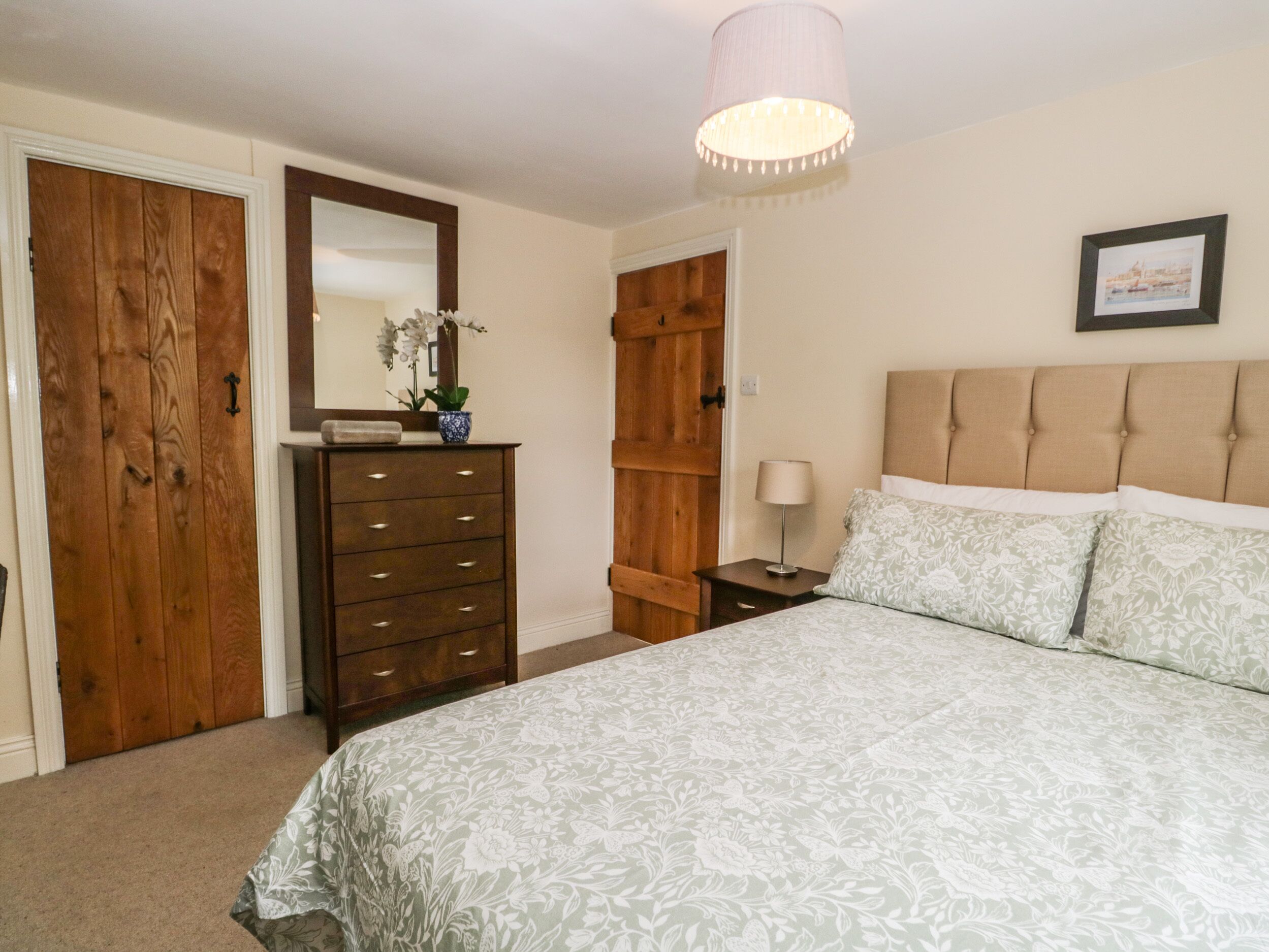 Une chambre à coucher avec un lit, une commode et un miroir.