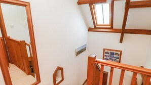 Un escalier avec des rampes en bois et une petite fenêtre en haut.