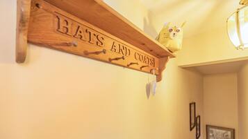 Een houten bord met de tekst 'HATS AND COATS' aan een muur.