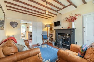 Una sala de estar acogedora con sofás de cuero, chimenea y televisión.