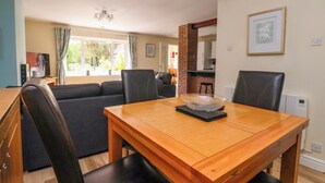 A dining area with a wooden table, black chairs, and a clear glass bowl on the table.