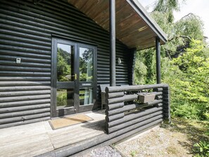 Eine Blockhütte mit einer Holzveranda und einer Glashaus-Tür.