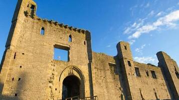 Un grand château en pierre, doté d’une arche centrale et de deux tours.
