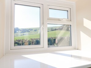 A window with a view of a green field and trees. - Parlour Cottage (Newport)