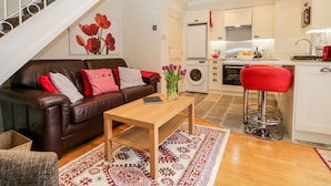 Un appartement moderne comprenant un salon, une cuisine et un escalier.