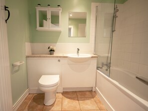 Une salle de bain avec des toilettes, un lavabo et une douche.