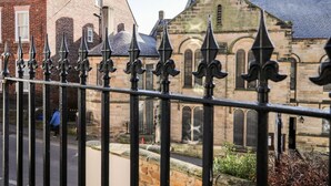 Een historisch gebouw van steen met boogvensters en een steil dak.