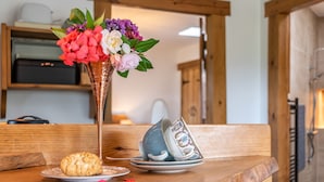 A wooden table with a plate of cookies, a vase of flowers, and a teacup. - The Lodge (Chester)