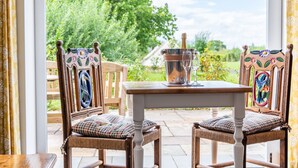 An outdoor patio with two wicker chairs, a table, and a bottle of champagne. - The Lodge (Chester)