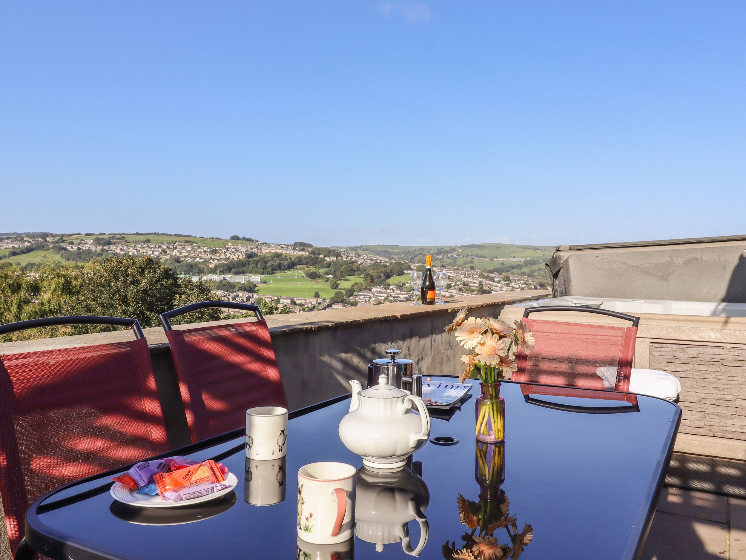 A table set for tea with a view of a town and countryside.