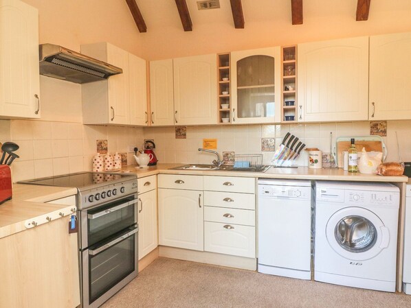 Efficient kitchen with gas stove, oven, dishwasher, and washing machine.