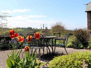 Sit and enjoy the serene garden surroundings with a view of the forest.