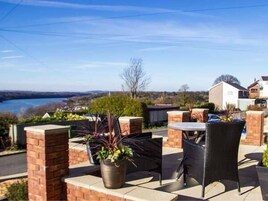 An outdoor patio area with brick walls, a table, and chairs.
