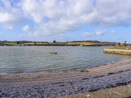 A beach with a rocky shoreline and calm water.