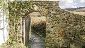 Un arc en pierre mène à un bâtiment en pierre au style rustique.