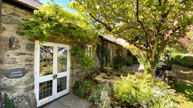 A stone cottage with a white door and a sign reading "Hendy Cottage." - Hendy Cottage (Pwllheli)