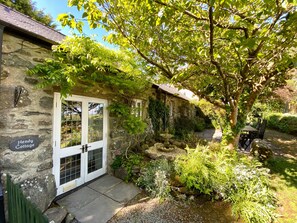 A stone cottage with a white door and a sign reading "Hendy Cottage." - Hendy Cottage (Pwllheli)
