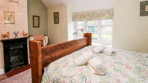 Ein Schlafzimmer mit einem hölzernen Bett, einem Kamin und einem Fenster mit Ausblick.