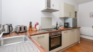 A compact kitchen with a sink, toaster, kettle, and a microwave. - Beacon (Saltburn-by-the-Sea)