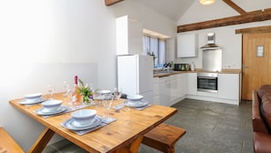 Una cocina moderna con armarios blancos, horno integrado y microondas.
