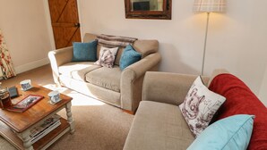 A cozy living room with a sofa, a coffee table, and a lamp.