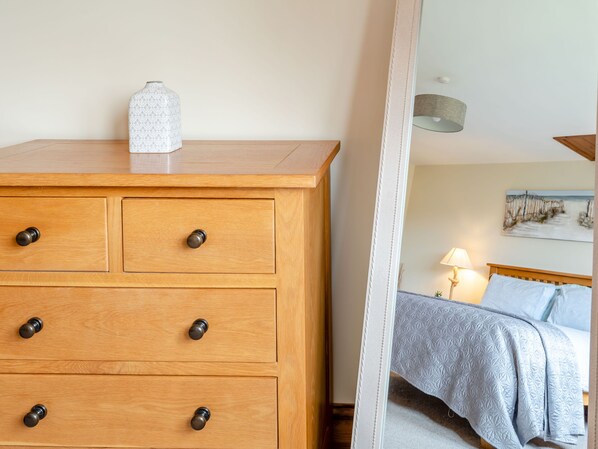 A wooden dresser with three drawers and a decorative vase on top. - The Nook (Louth)