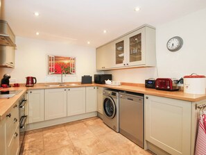 A modern kitchen with a washing machine, a microwave, and a toaster. - Swallows Cottage (Shrewsbury)