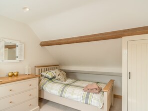 Quarto com cama, penteadeira, espelho e guarda-roupa.