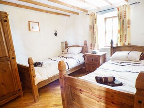 A wooden room with two beds, a wardrobe, and a small table. - The Old Granary (Haverfordwest)